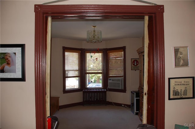 hall with radiator, baseboards, carpet, cooling unit, and an inviting chandelier