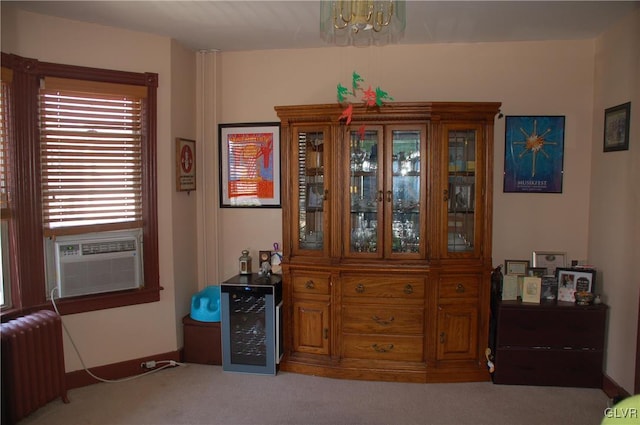 interior space featuring baseboards, carpet, a chandelier, radiator heating unit, and cooling unit