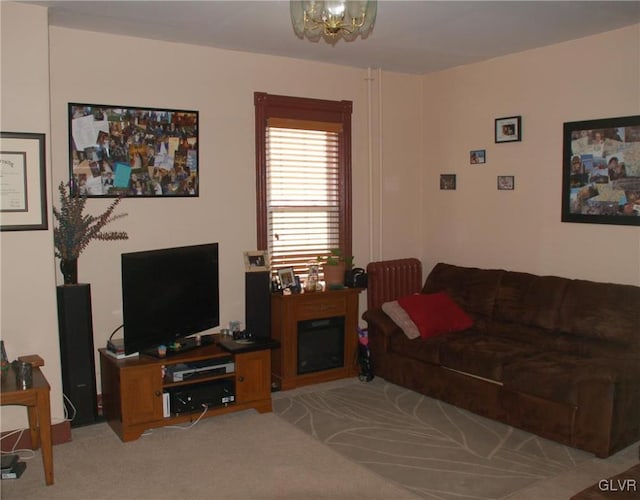 living area with light carpet, a notable chandelier, and a fireplace