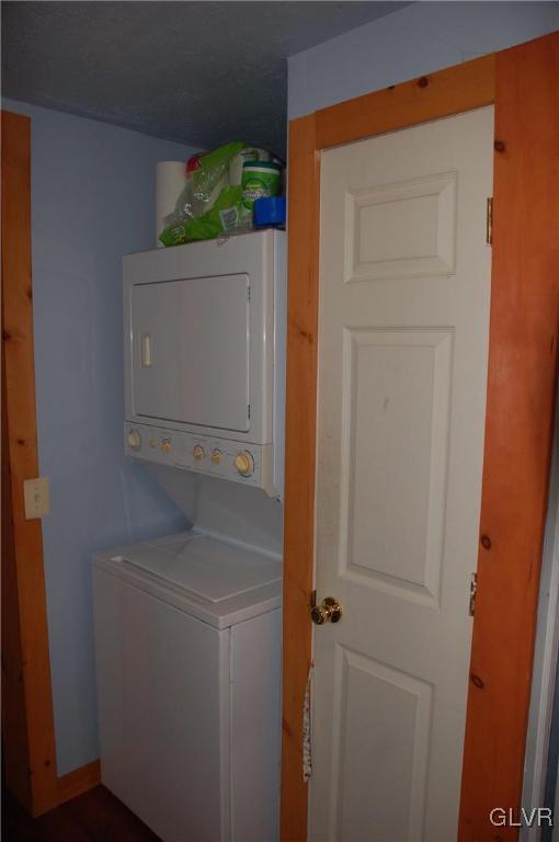 washroom with stacked washer / dryer and laundry area