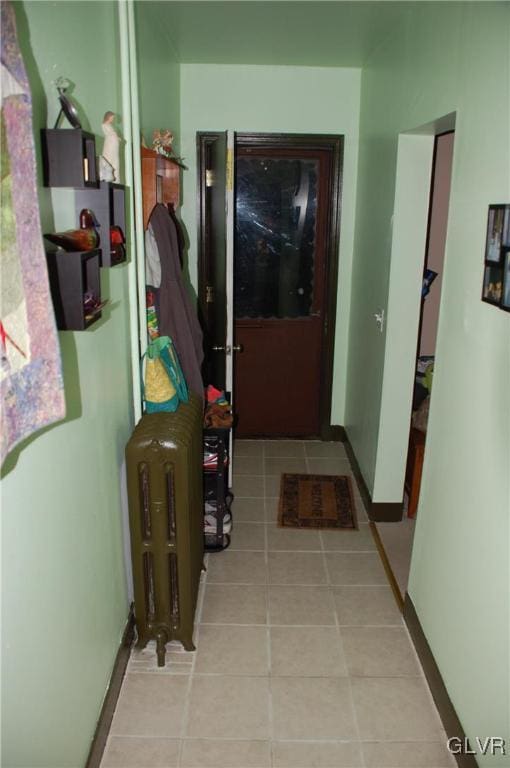 corridor featuring tile patterned flooring and baseboards