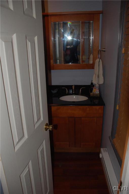 bathroom featuring a baseboard heating unit and vanity