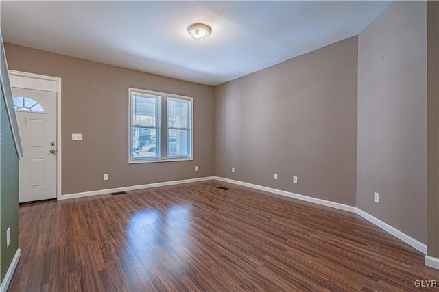 interior space featuring visible vents, baseboards, and dark wood-style flooring