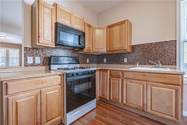 kitchen featuring light brown cabinets, a sink, light countertops, black microwave, and range with gas cooktop