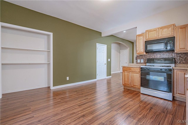 kitchen featuring dark wood-type flooring, light brown cabinetry, range with gas cooktop, arched walkways, and black microwave