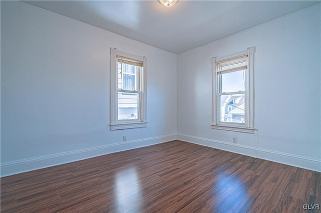 empty room with baseboards and dark wood finished floors