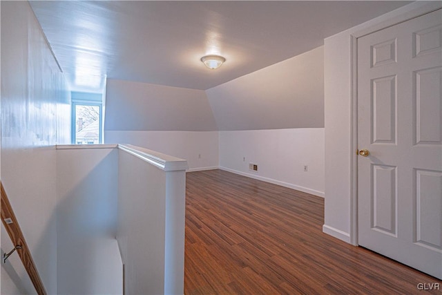 additional living space featuring vaulted ceiling, wood finished floors, visible vents, and baseboards