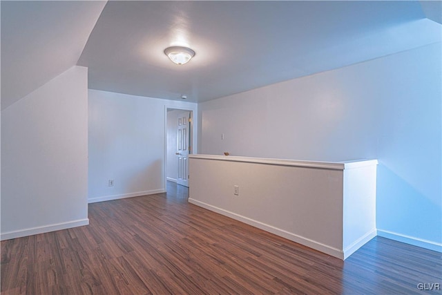 unfurnished room with baseboards and dark wood-style floors