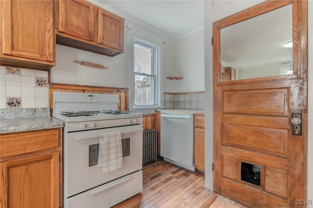 kitchen with white gas stove, ornamental molding, tasteful backsplash, light countertops, and dishwasher