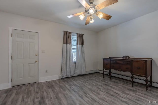 entrance foyer featuring ceiling fan, baseboards, baseboard heating, and wood finished floors