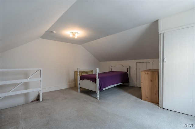 unfurnished bedroom with vaulted ceiling and carpet floors