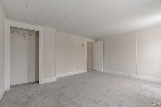 unfurnished bedroom with a closet and light colored carpet