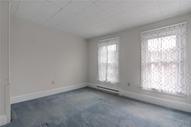 empty room with carpet flooring, a baseboard heating unit, and baseboards