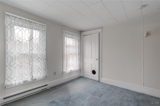 carpeted spare room with a baseboard radiator and baseboards