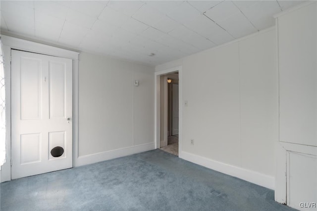 carpeted empty room featuring baseboards