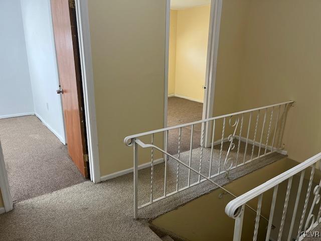 stairs with baseboards and carpet