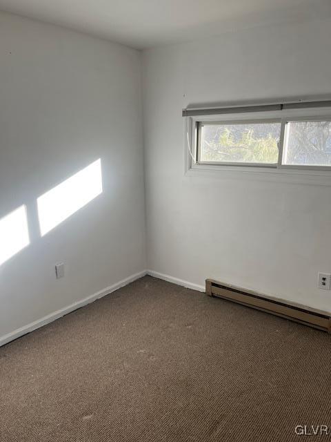 carpeted spare room featuring baseboards and baseboard heating