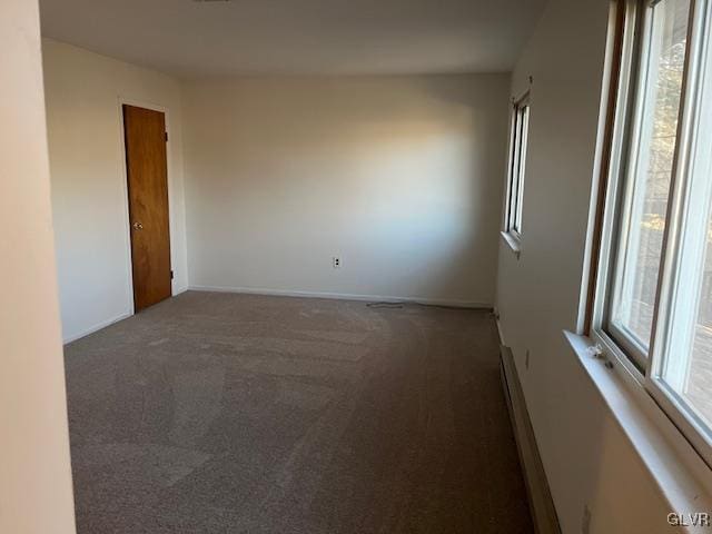 carpeted empty room featuring baseboards