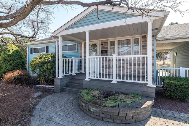 view of front of property with roof with shingles and a porch