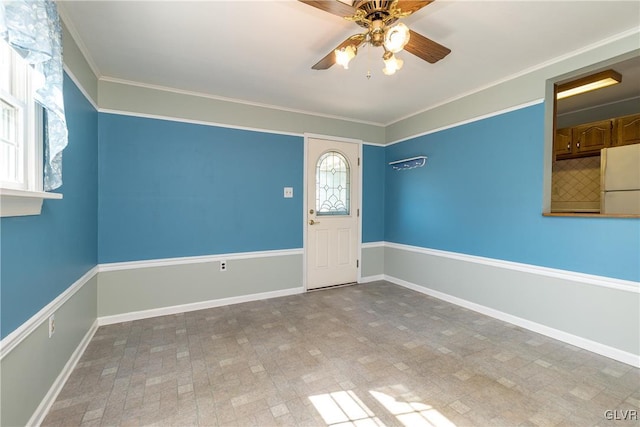 unfurnished room with baseboards, ceiling fan, and crown molding