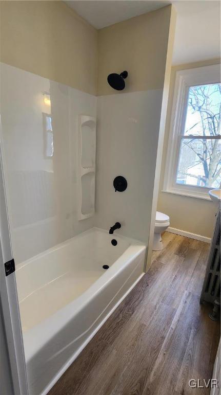 bathroom featuring shower / bath combination, toilet, and wood finished floors