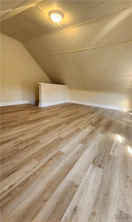 bonus room featuring vaulted ceiling and wood finished floors