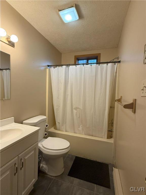 248 Penn Forest Trl, Penn Forest Township, PA 18210 - bathroom with tile patterned floors, shower / bath combo with shower curtain, toilet, a textured ceiling, and vanity