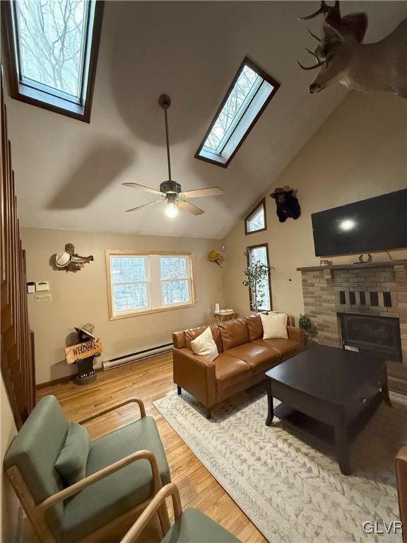 248 Penn Forest Trl, Penn Forest Township, PA 18210 - living room with a ceiling fan, wood finished floors, a skylight, baseboard heating, and a brick fireplace