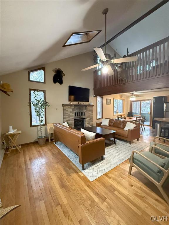 248 Penn Forest Trl, Penn Forest Township, PA 18210 - living area with a glass covered fireplace, high vaulted ceiling, ceiling fan, and wood-type flooring