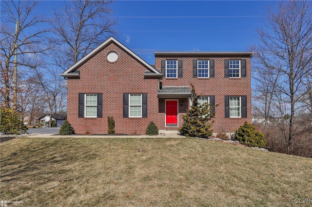 view of front of house with brick siding and a front lawn