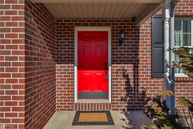 view of exterior entry with brick siding