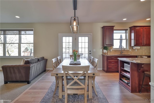 dining room with recessed lighting, light wood-type flooring, and baseboards