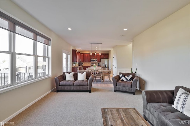 living area featuring recessed lighting, light colored carpet, and baseboards