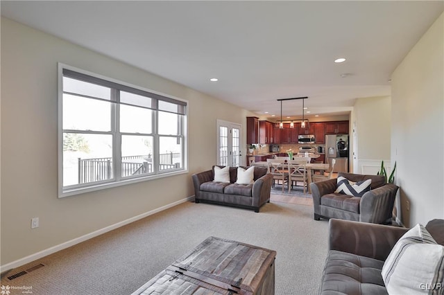 carpeted living area with recessed lighting, visible vents, and baseboards