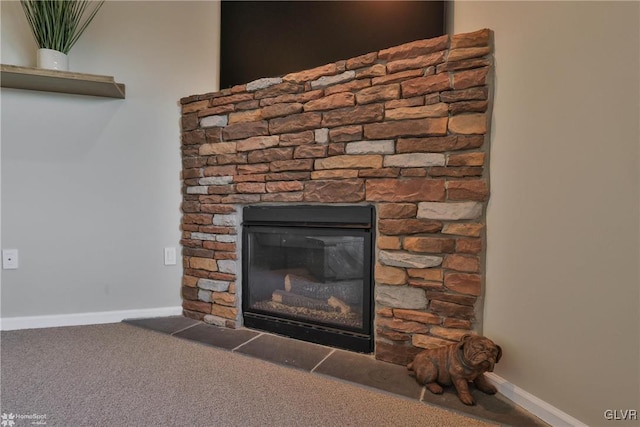 details featuring a stone fireplace, carpet, and baseboards