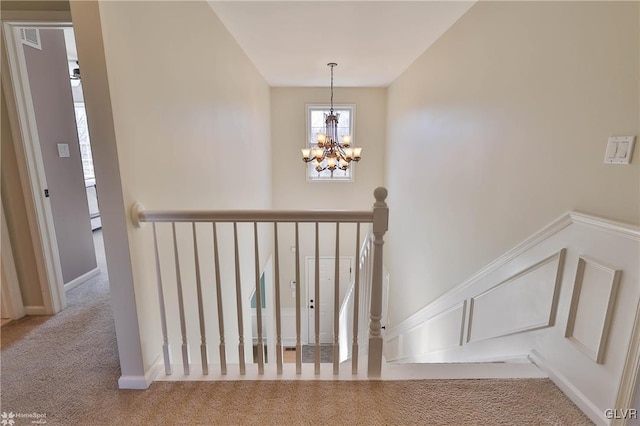 staircase featuring a notable chandelier, carpet, and visible vents