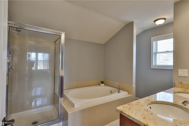 bathroom featuring a sink, a stall shower, double vanity, and vaulted ceiling