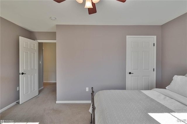 bedroom featuring baseboards, light colored carpet, and ceiling fan