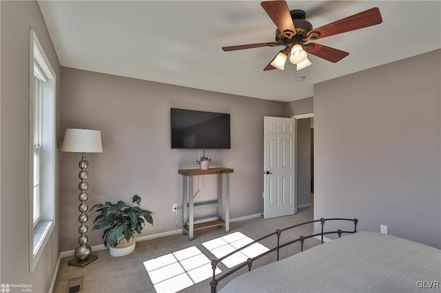 carpeted bedroom featuring visible vents, a ceiling fan, and baseboards