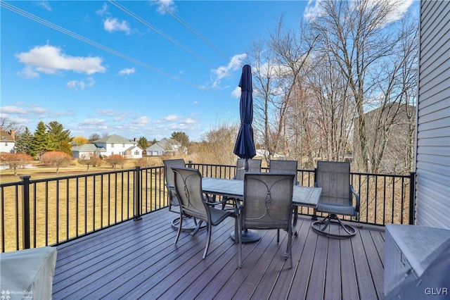 wooden deck with outdoor dining space and a lawn