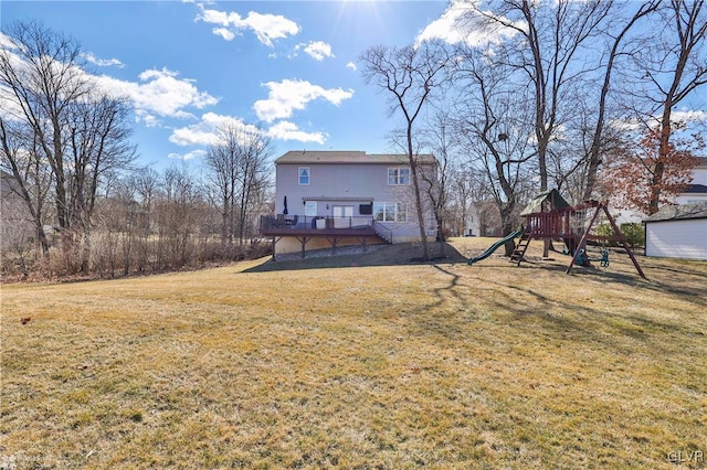 rear view of house featuring a wooden deck, a playground, and a yard