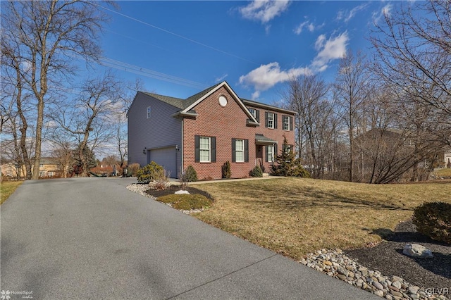 view of home's exterior featuring aphalt driveway, a garage, a yard, and brick siding