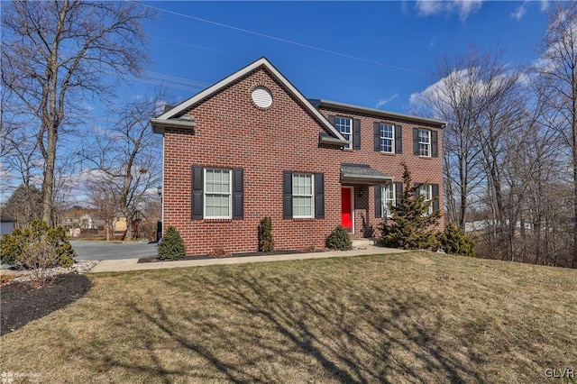 colonial house with a front lawn and brick siding