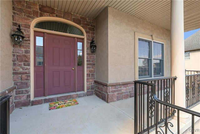 entrance to property with stucco siding and brick siding