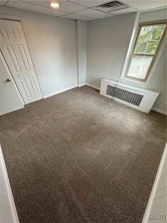 unfurnished room with baseboards, visible vents, a paneled ceiling, and carpet floors