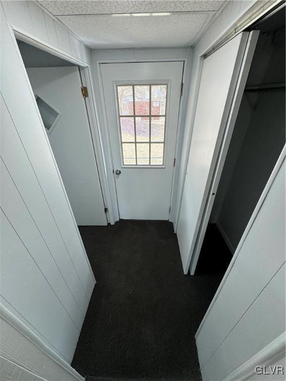 doorway to outside featuring dark carpet