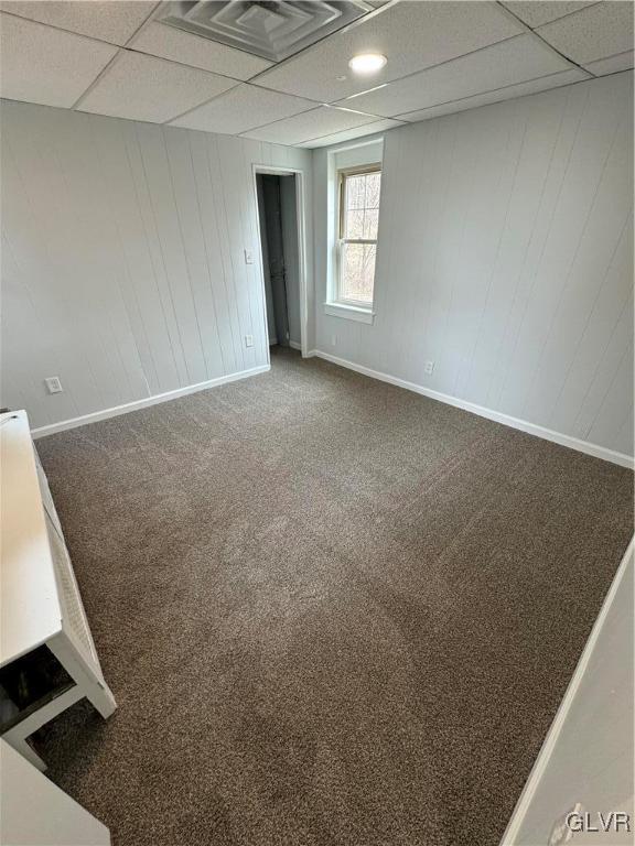 unfurnished room featuring baseboards, a paneled ceiling, and carpet flooring