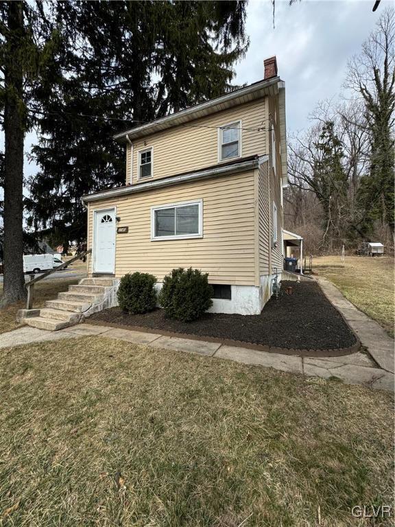 view of front of property with a chimney and a front lawn