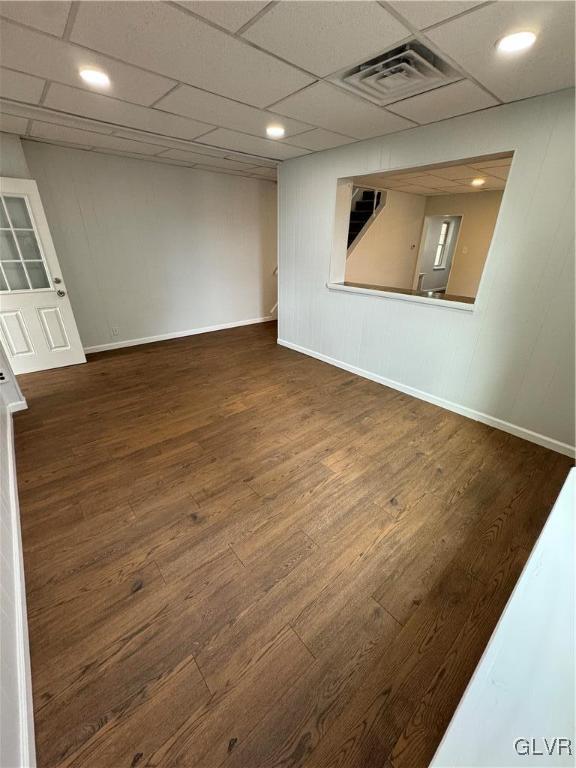 unfurnished room with visible vents, a paneled ceiling, baseboards, and wood finished floors