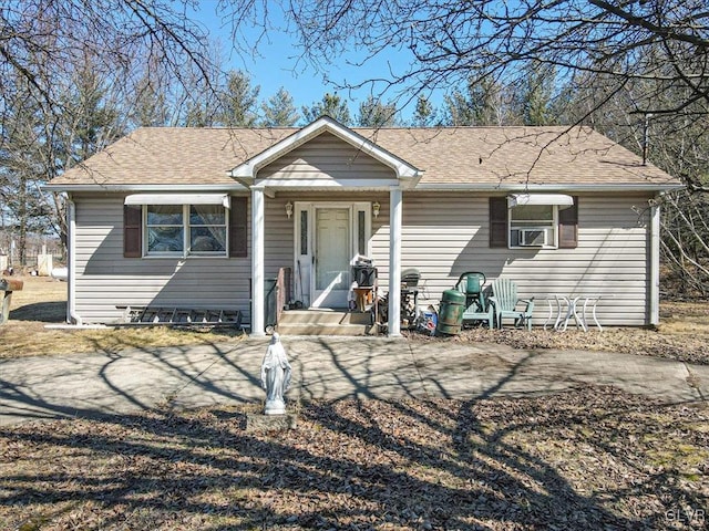 view of front of property featuring cooling unit and roof with shingles